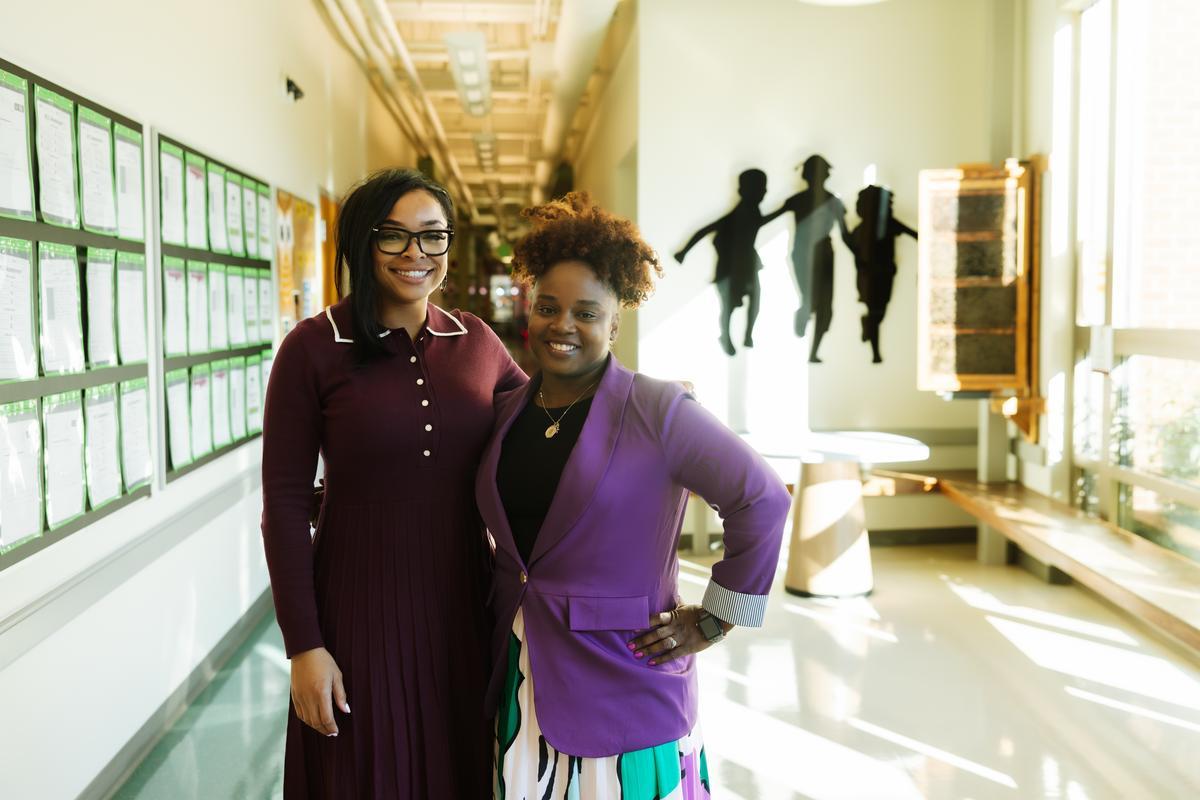 Two Meeting Street Schools colleagues smiling in a school hallway